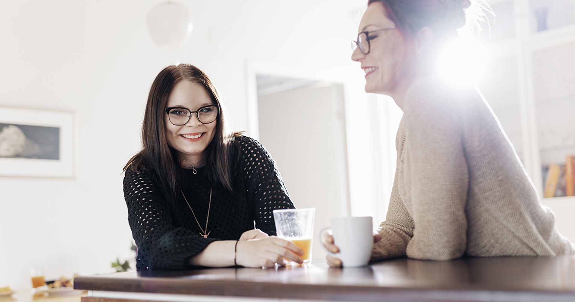 Two people sitting around a table and smiling.