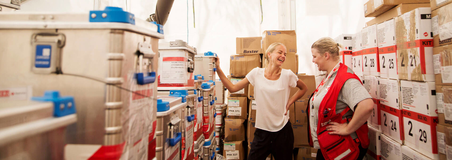 Two delegates laughing together amongst ERU boxes.
