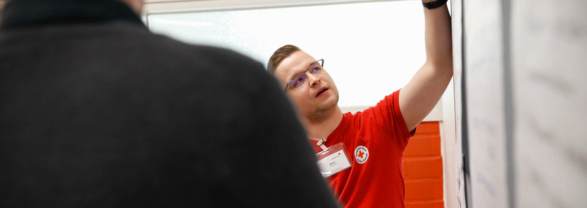 A Finnish Red Cross trainer is presenting a flip chart.