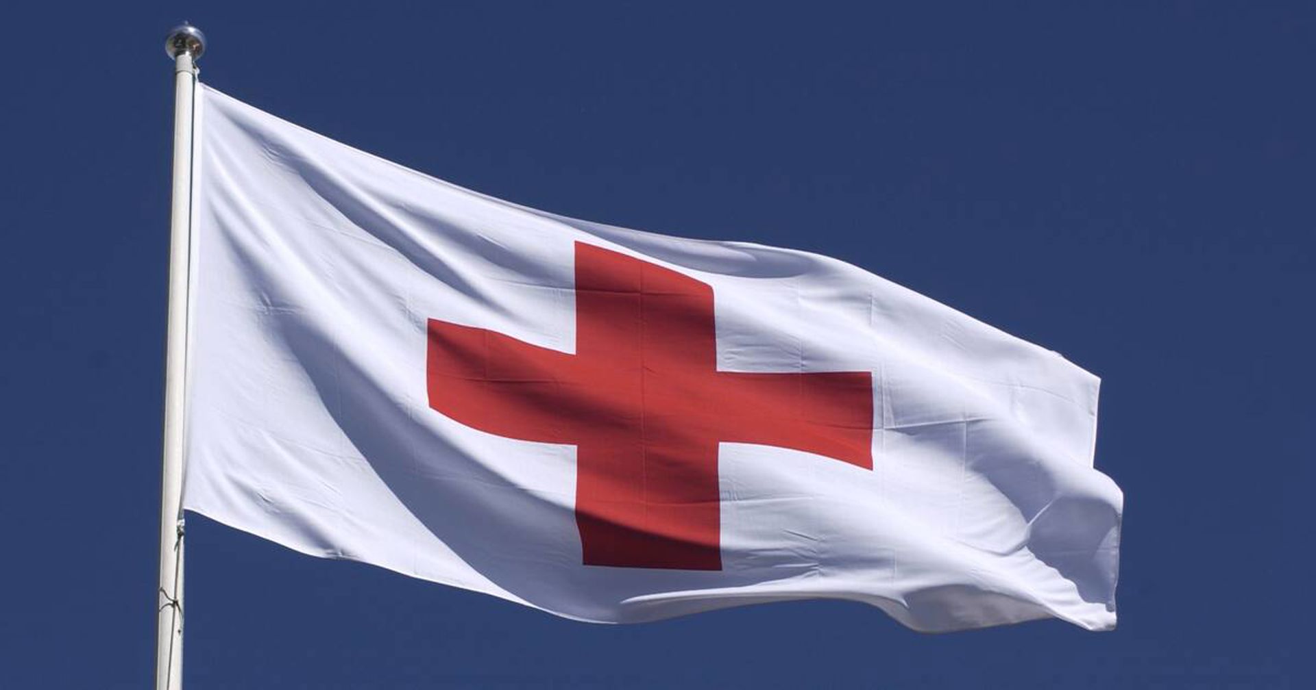 The Red Cross flag flying on a flagpole.