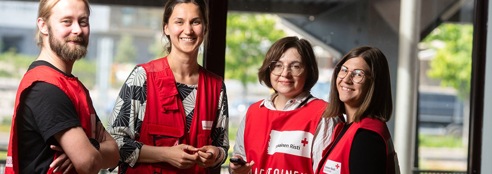 Four Red Cross volunteers standing and smiling at the camera.