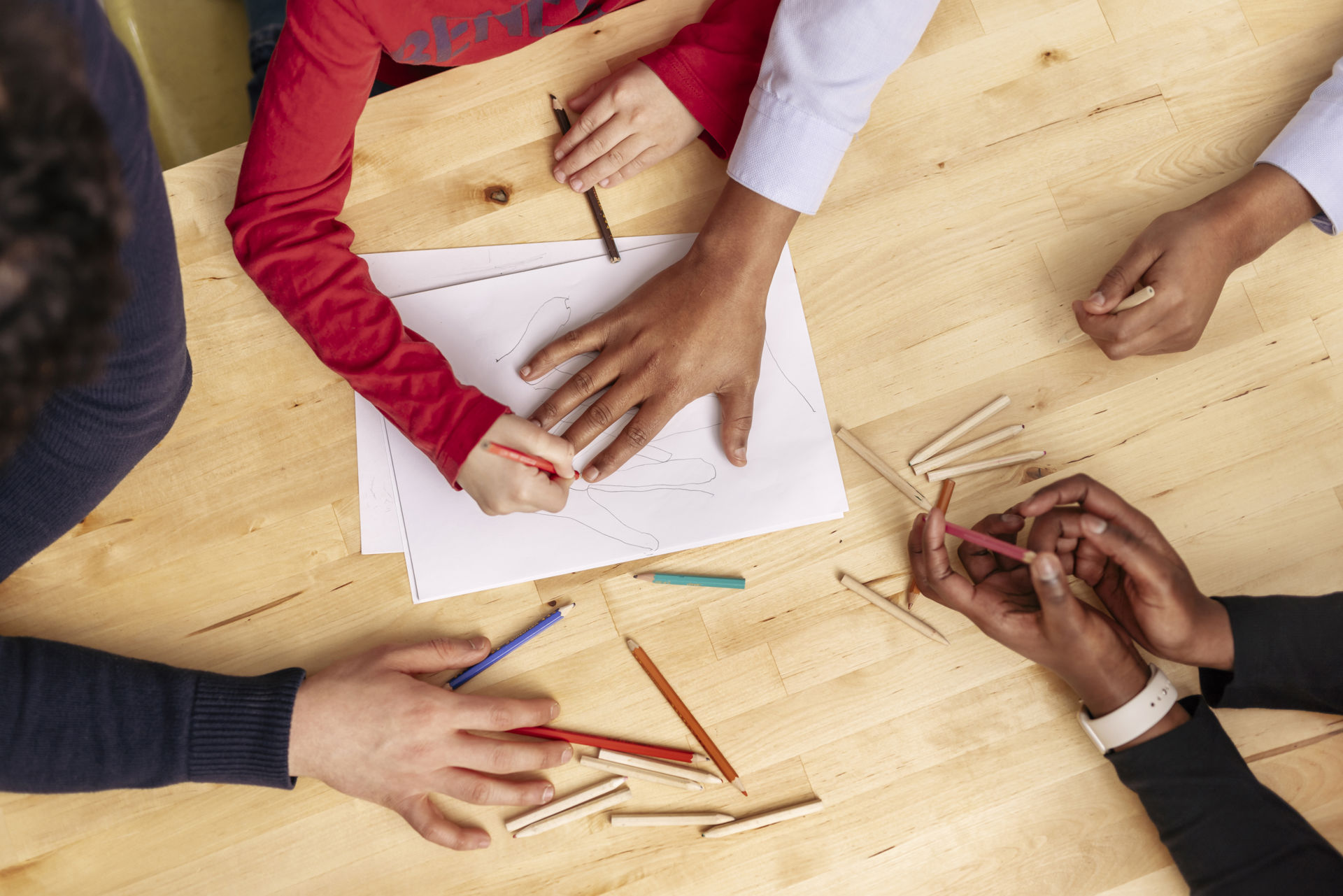 Hands drawing on a table.