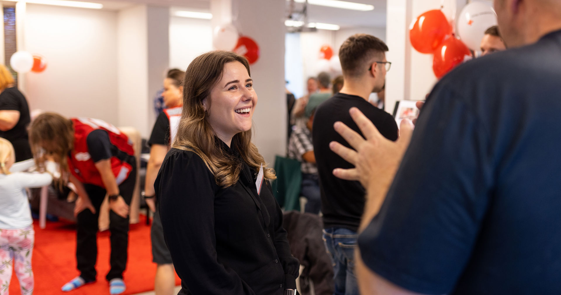 A person smiles at another at a Red Cross event.