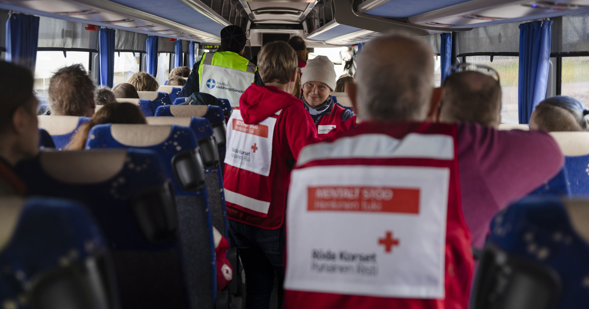 Red Cross volunteers on a bus in their volunteer vests.