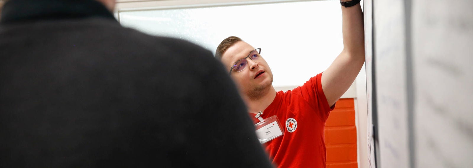 A Finnish Red Cross trainer is presenting a flip chart.