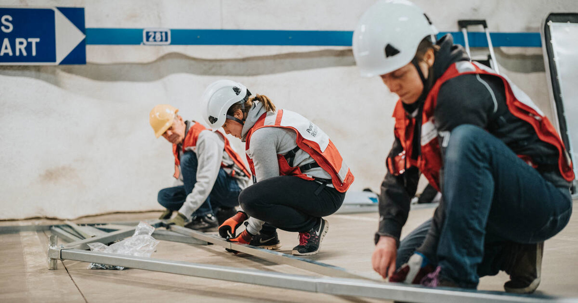 Three volunteers working on a construction task.