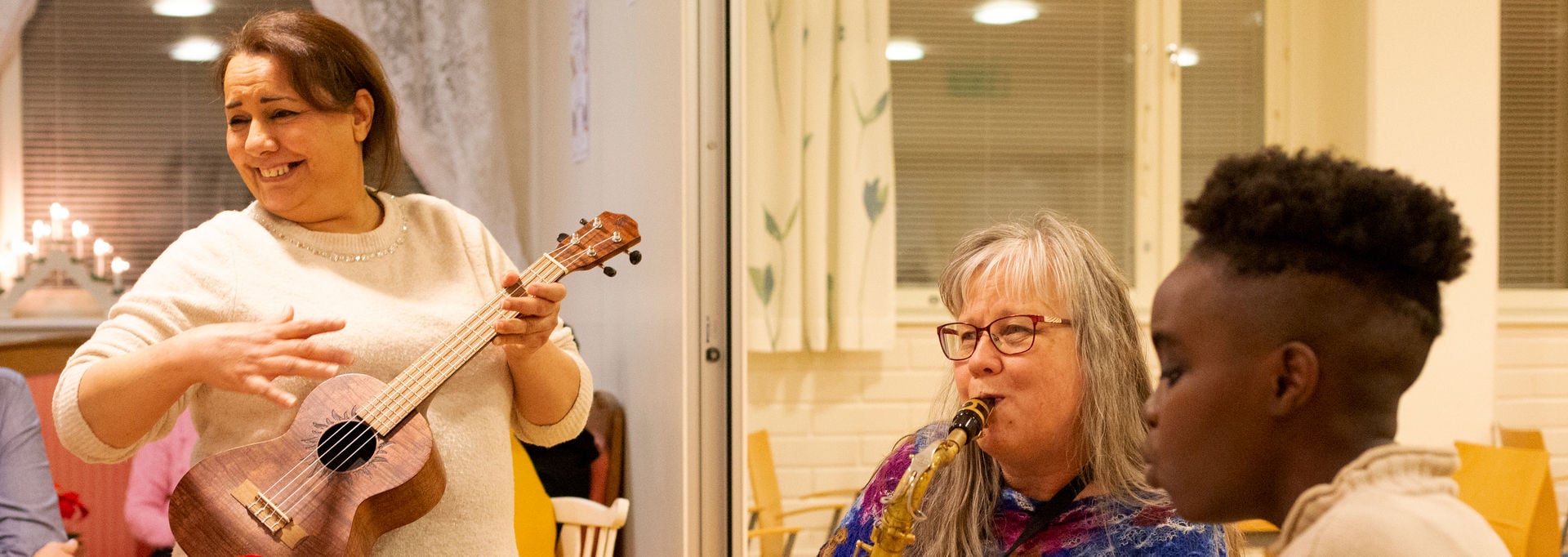 Three people playing music and singing together.