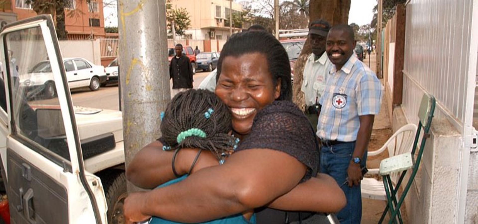 A person hugging another person and smiling happily.