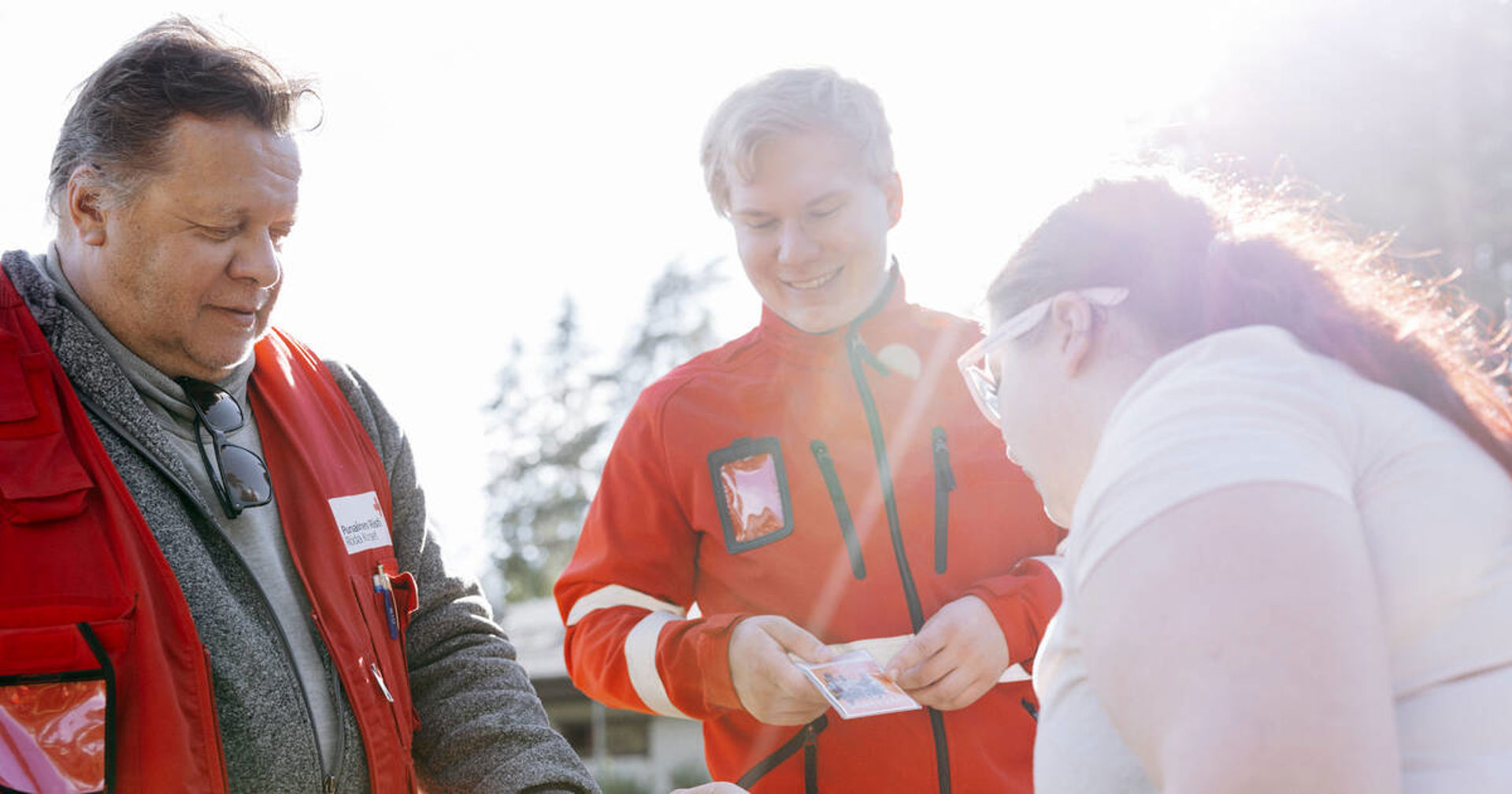 Two Red Cross volunteers talking with a young person.