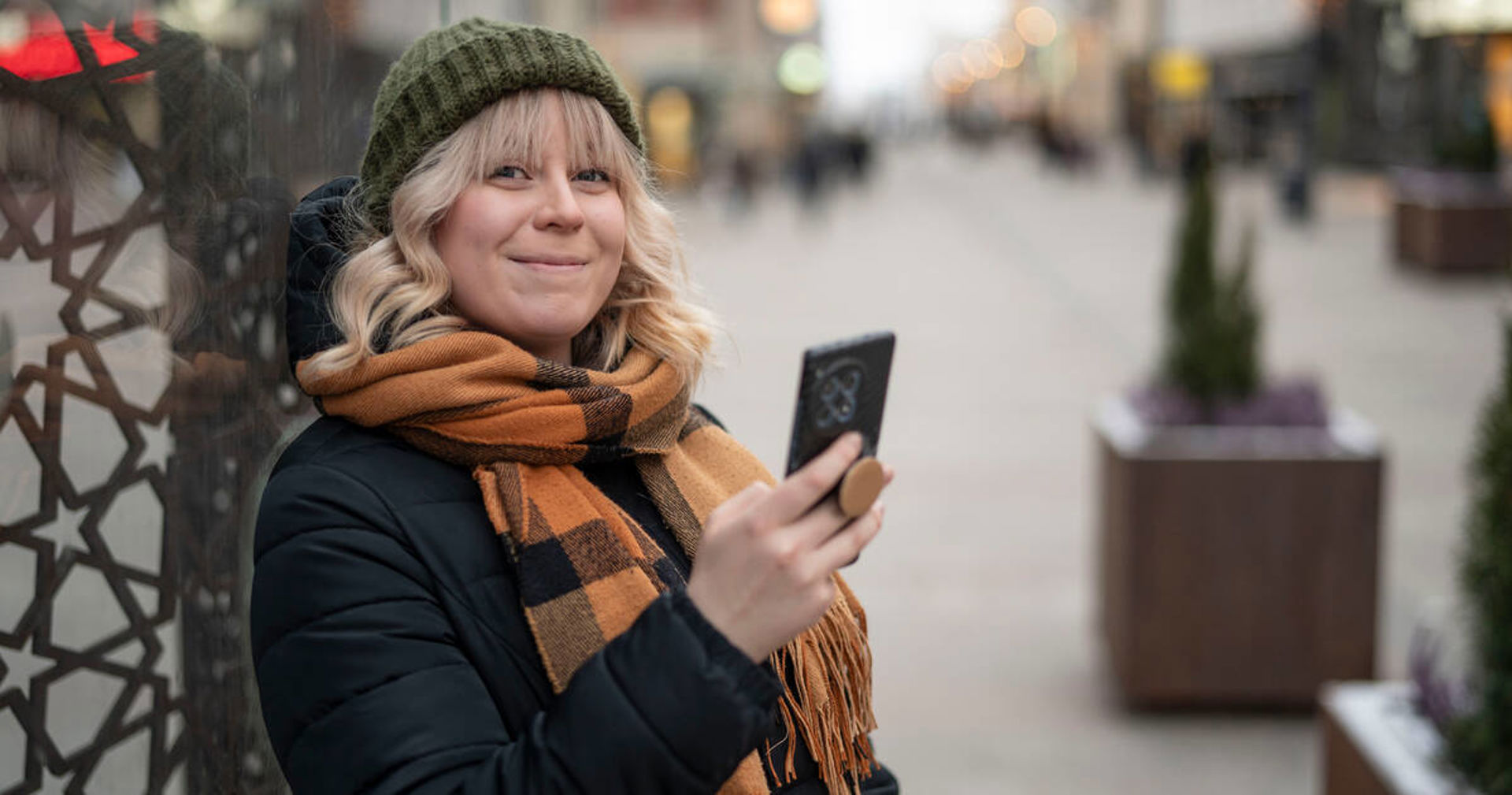 A person smiling with a phone in their hand.