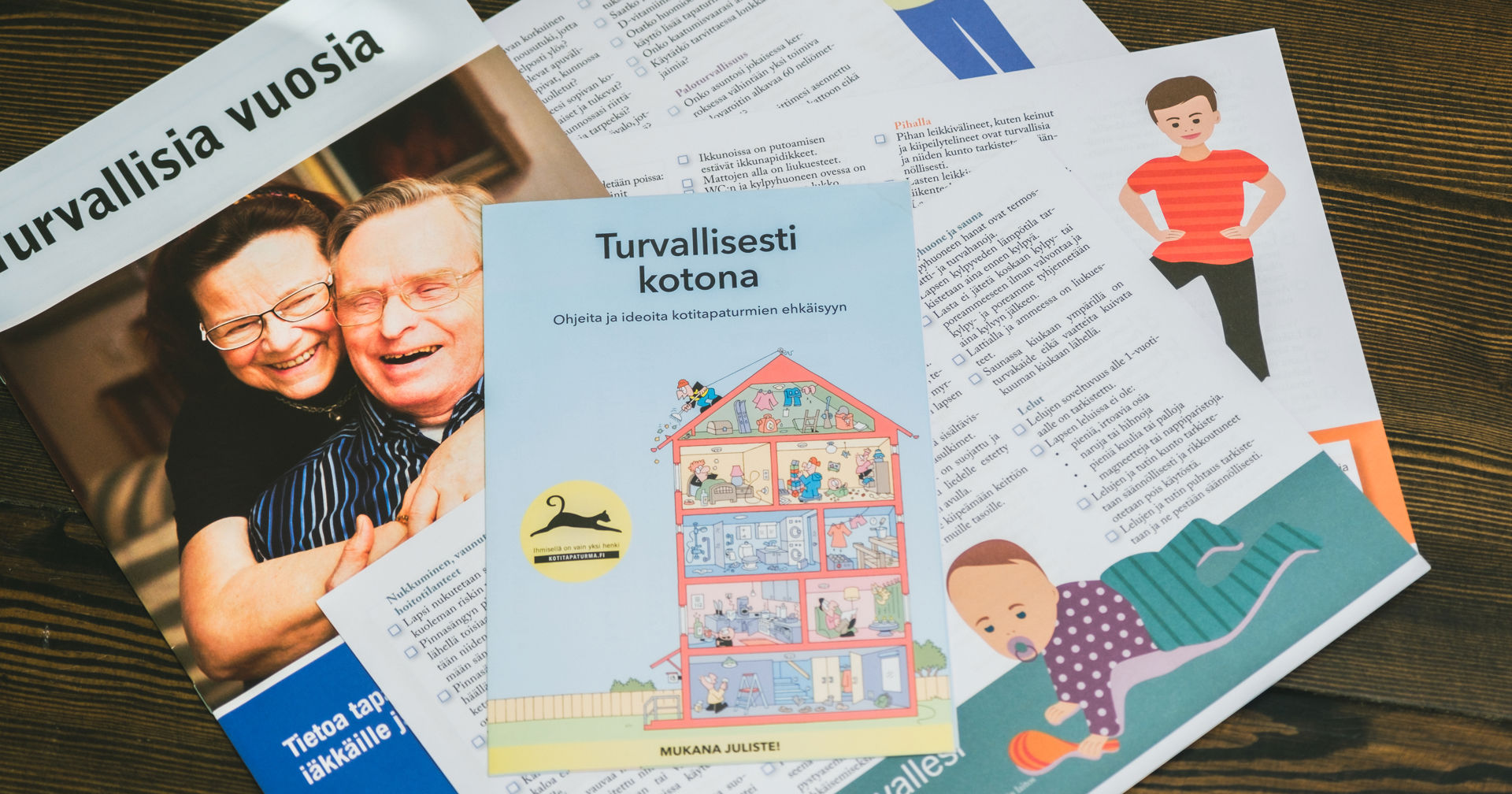 Safety brochures on the table. One reads: "safe years", and the other, "safely at home."