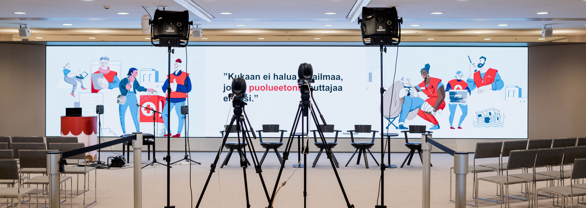 Red Cross imagery and text projected onto a wall: "No one wants a world where an impartial helper would not exist."