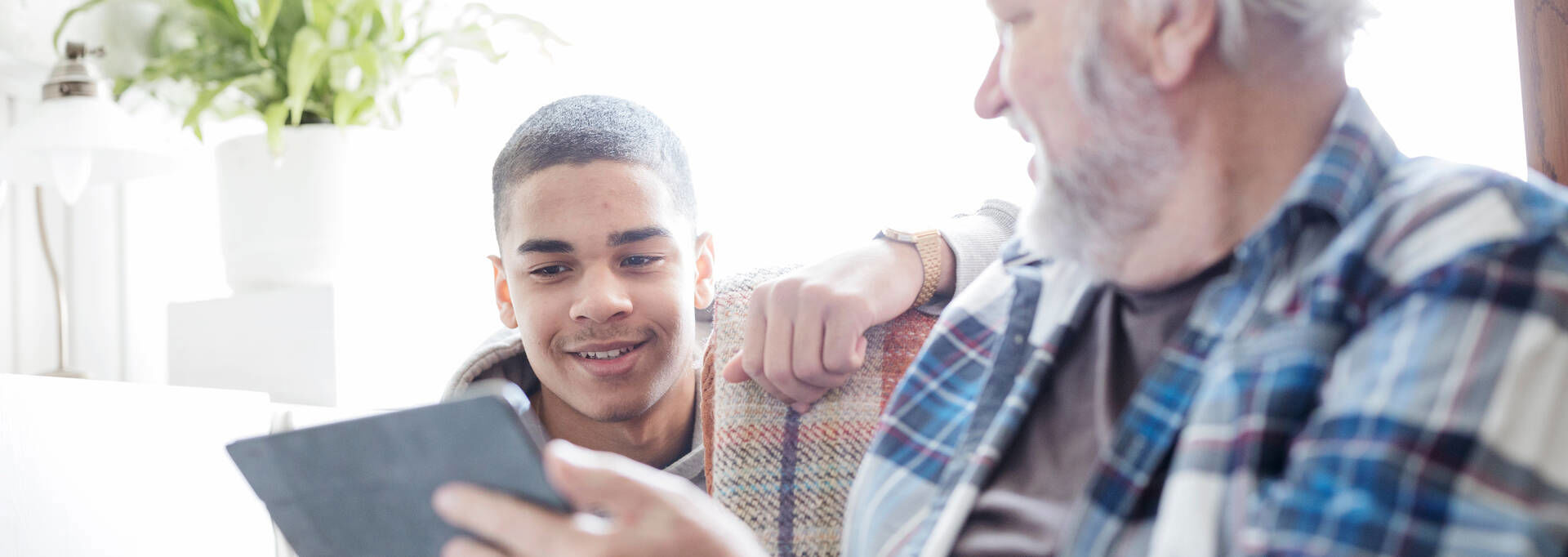 Two people are browsing a tablet.